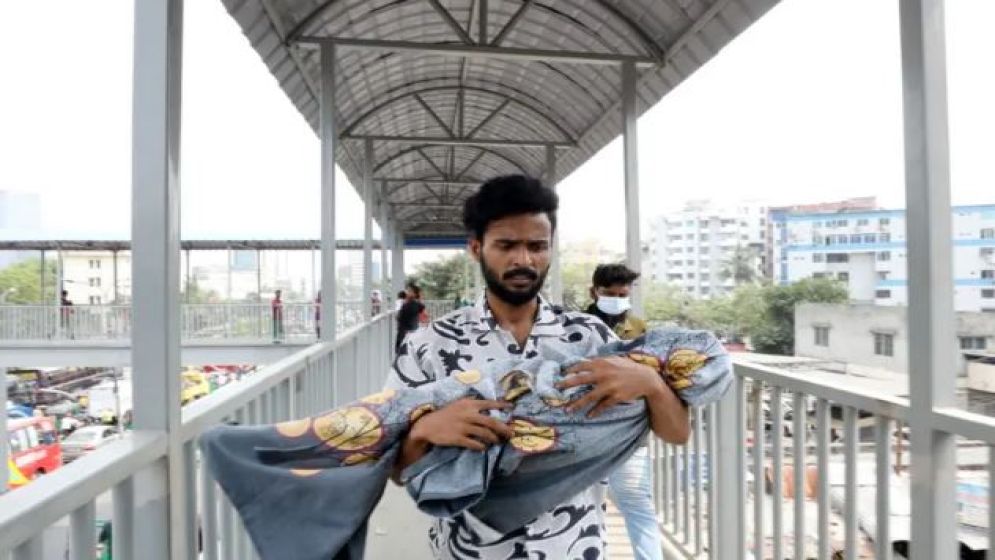 যুবকের কোলে চাদরে মোড়ানো শিশু- ছবির পেছনের ঘটনা যা জানা যাচ্ছে